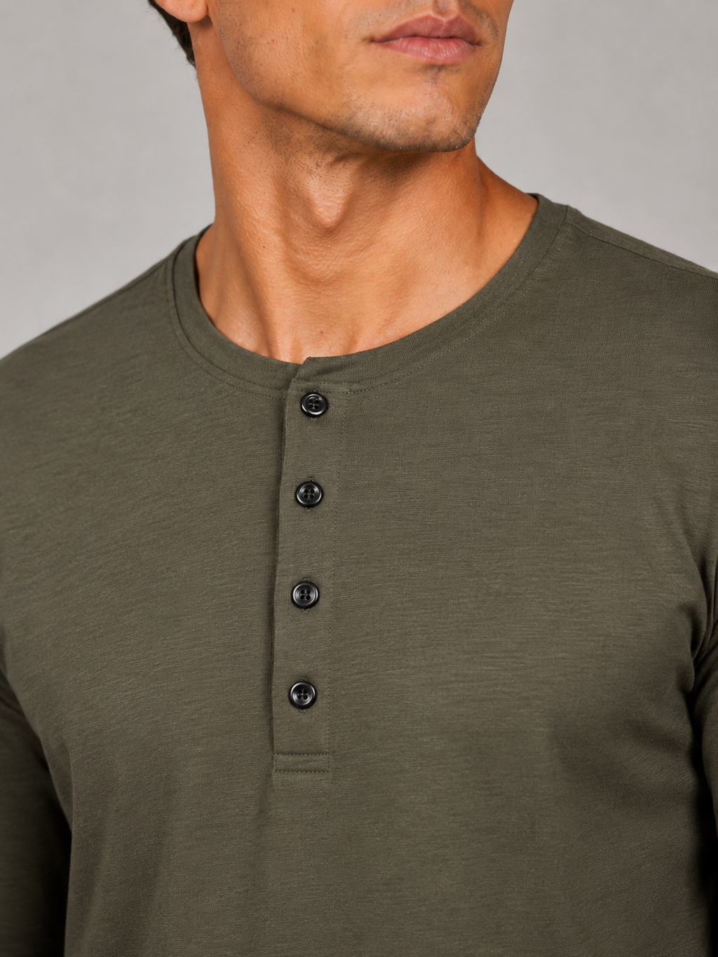 Close up of army green henley shirt fabric showing soft smooth breathable texture and button detail