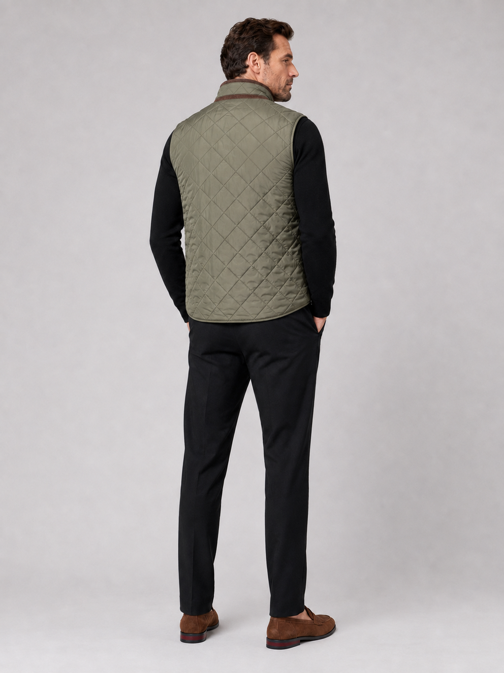 Back view of a man wearing an army green quilted vest showing the padded construction, sleeveless cut, and comfortable fit