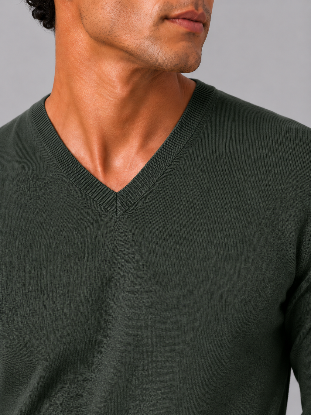 Close up of army green knit sweater showing soft lightweight fabric and refined v neck detail