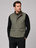 Front view of a man wearing an army green quilted vest with a polo collar, padded construction, and multiple utility pockets