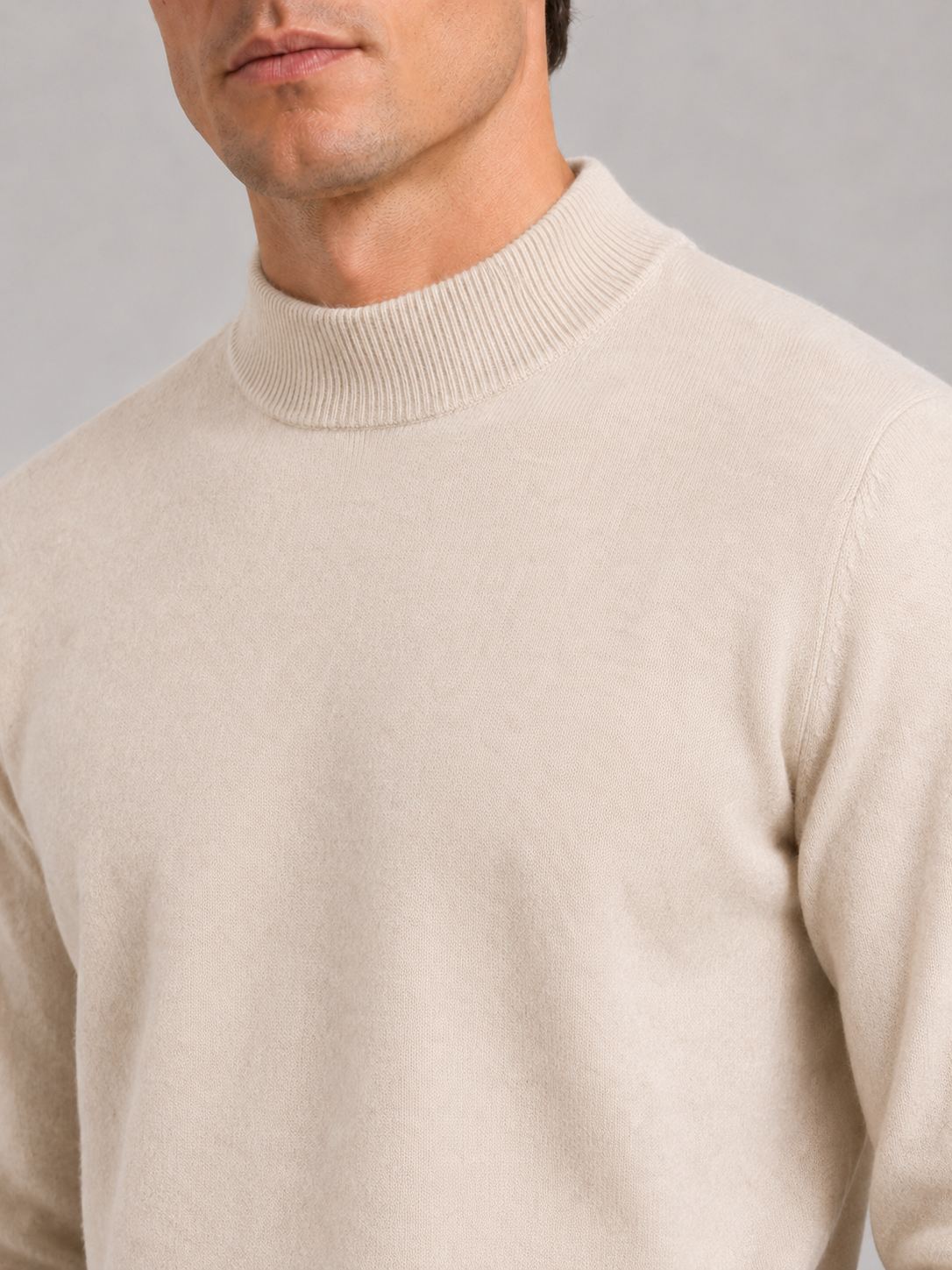 Close up of beige wool mock neck sweater showing soft premium knit texture and refined collar detail