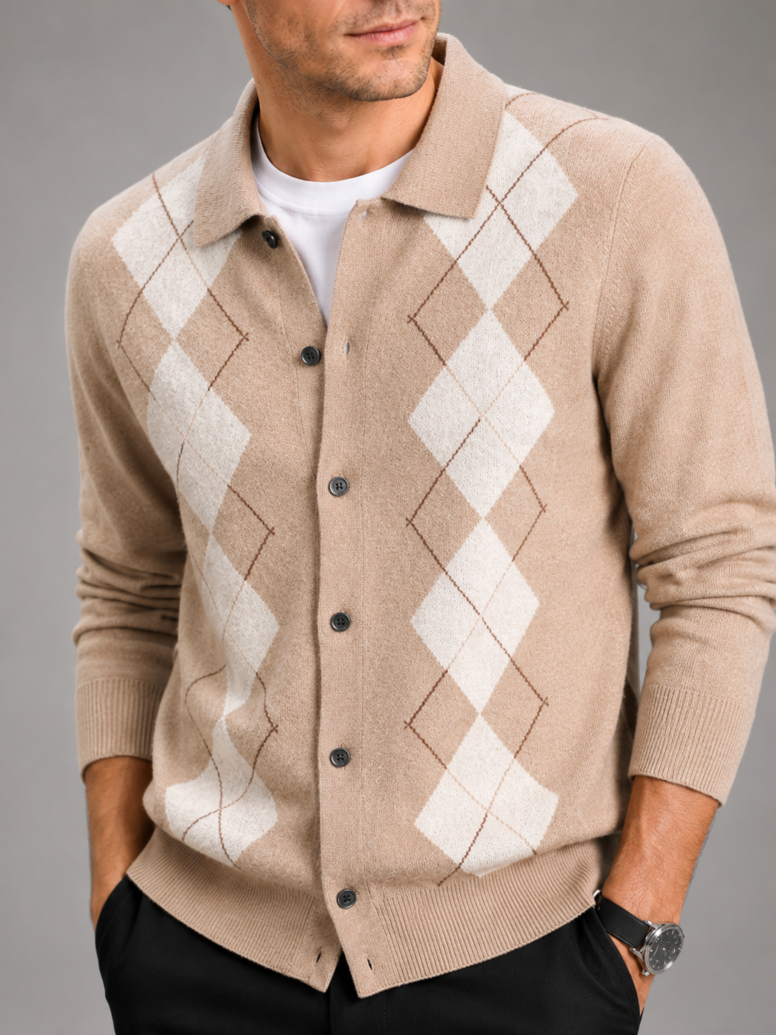 Close-up of a black argyle cardigan sweater showing the diamond pattern, thick knit texture, buttons, turn-down collar, ribbed cuffs, and hem