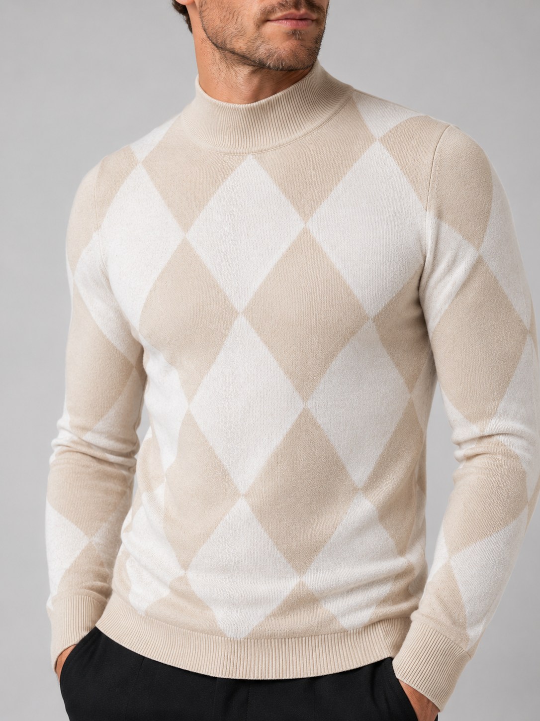 Close-up of a beige argyle turtleneck sweater showing the diamond knit pattern, stretch knit texture, turtleneck collar, ribbed cuffs, and hem