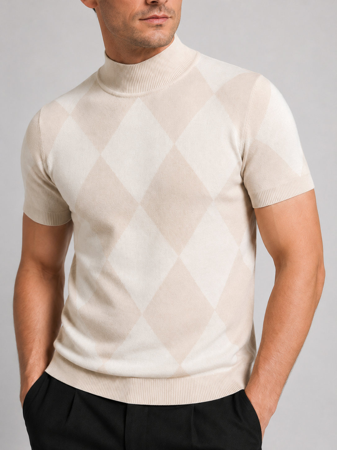 Close-up of a beige argyle turtleneck T-shirt showing the diamond lattice pattern, knit texture, high neckline, short sleeve cuffs, and stitching details