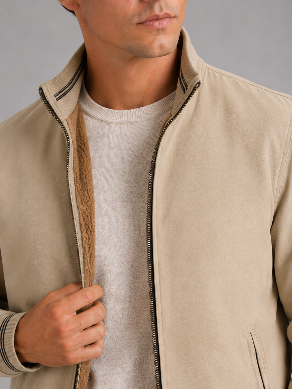 Close up of beige aviator jacket showing soft fleece lining and durable zipper detail