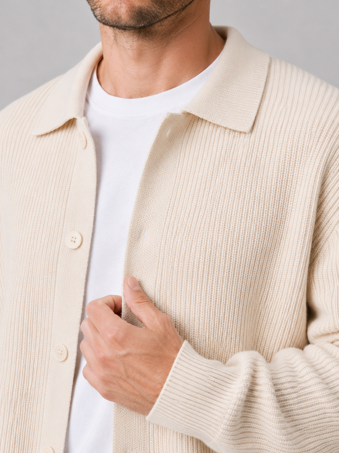 Close up of beige knit cardigan showing soft textured fabric and relaxed lapel collar detail