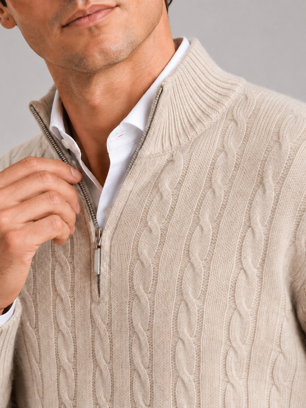 Close up of beige cashmere sweater showing soft cable knit texture and quarter zip detail