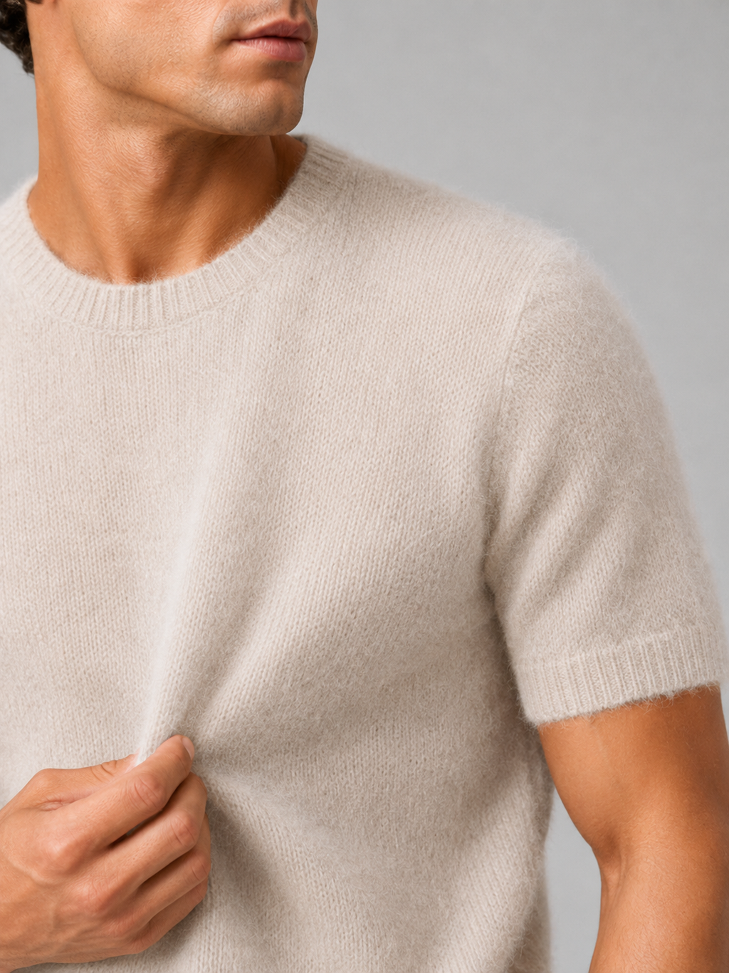 Close up of beige cashmere knit t shirt showing soft luxurious texture and refined crew neck detail