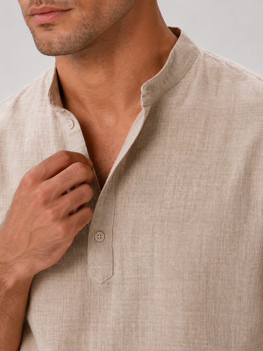 Close up of beige band collar shirt showing soft breathable fabric and button up detail