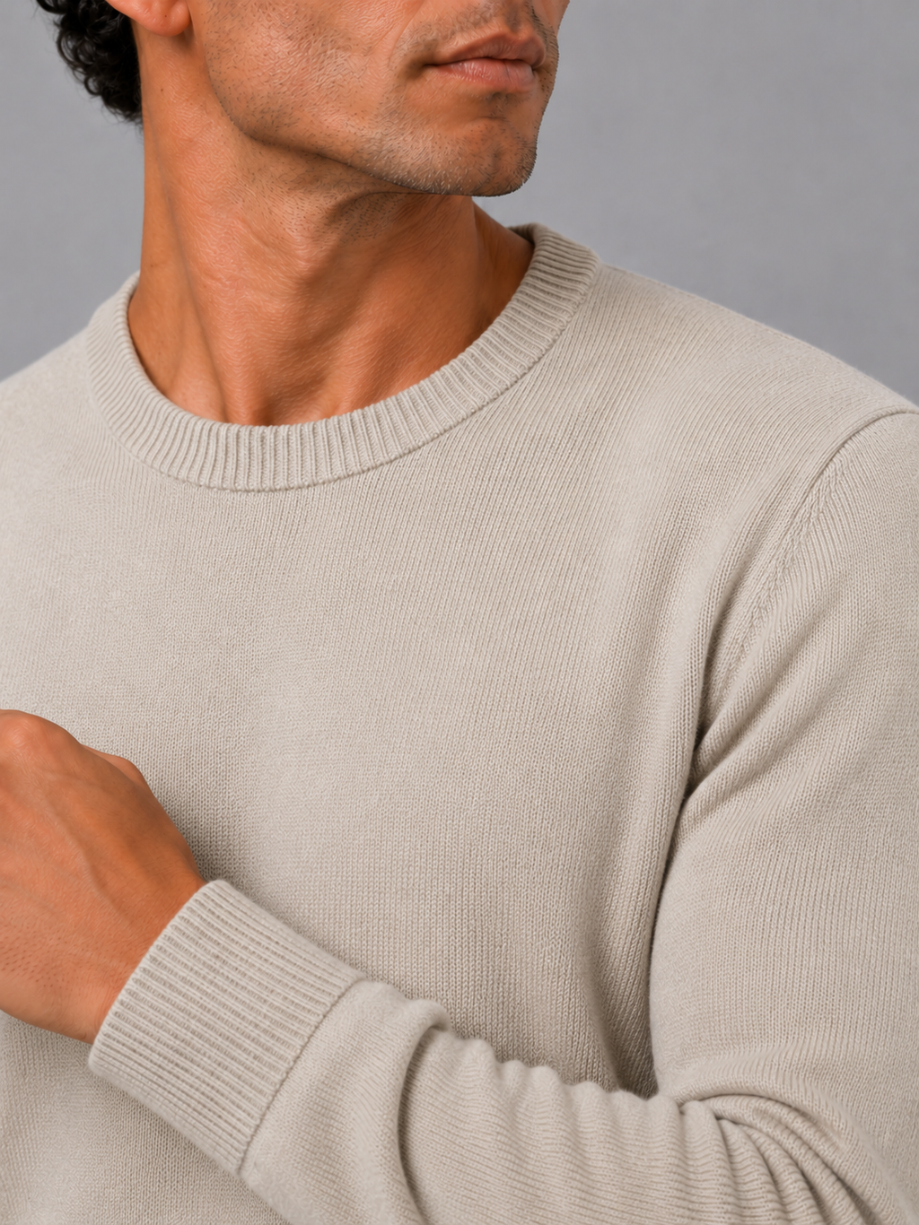 Close up of beige knit sweater showing soft lightweight fabric and clean crew neck detail