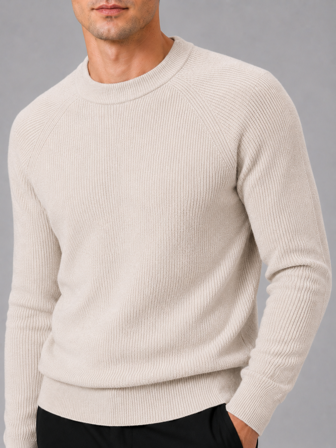 Close up of beige knit sweater showing thick soft fabric and classic crew neck detail