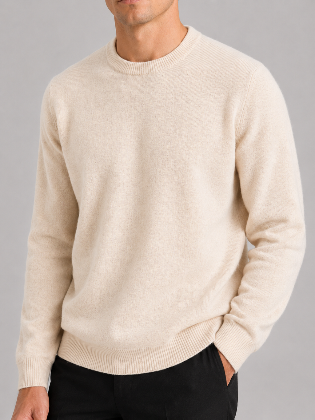 Close up of beige knit sweater showing soft textured fabric and classic crew neck detail