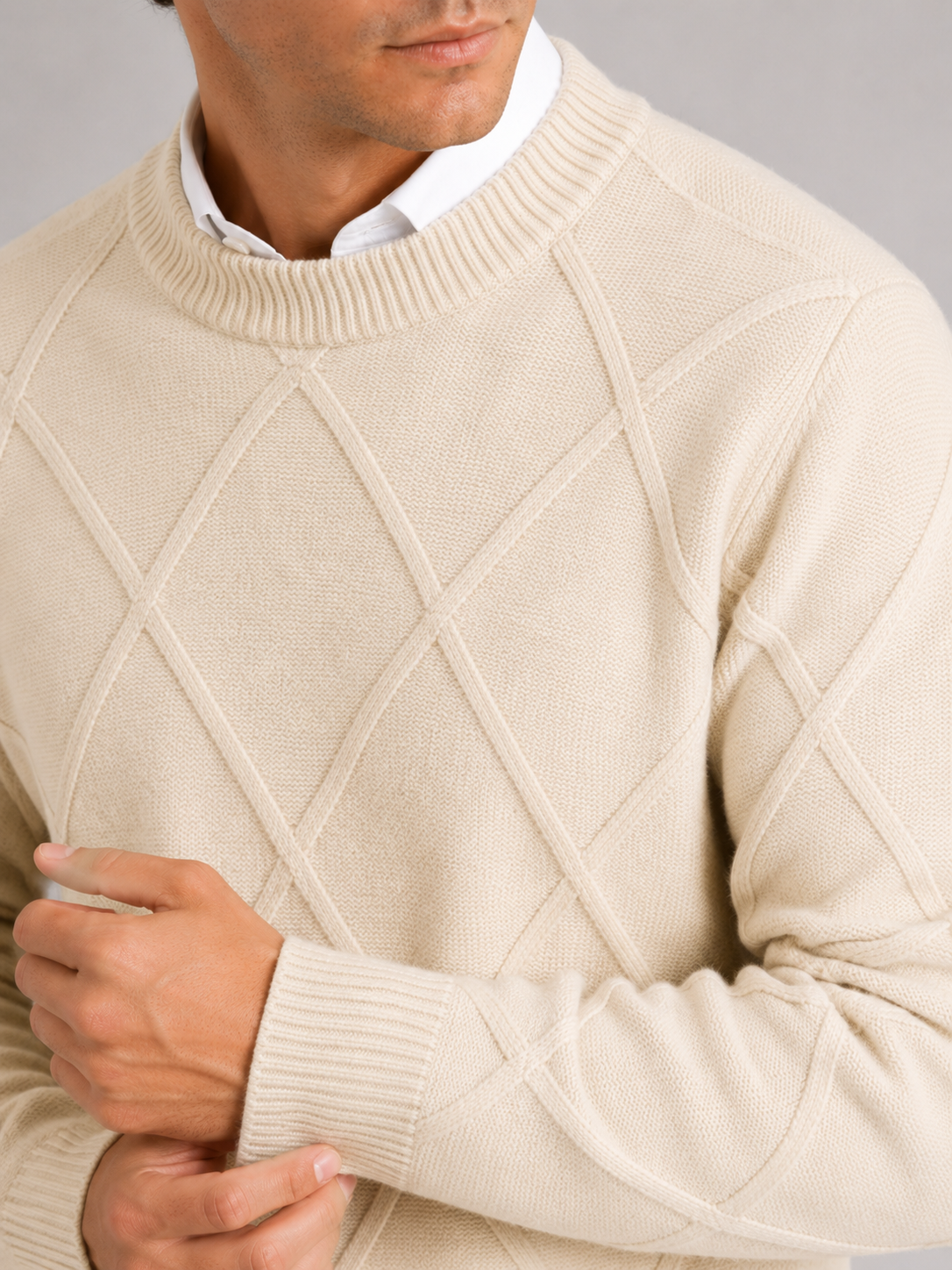 Close up of beige cable knit sweater showing soft fleece texture and thick woven detail