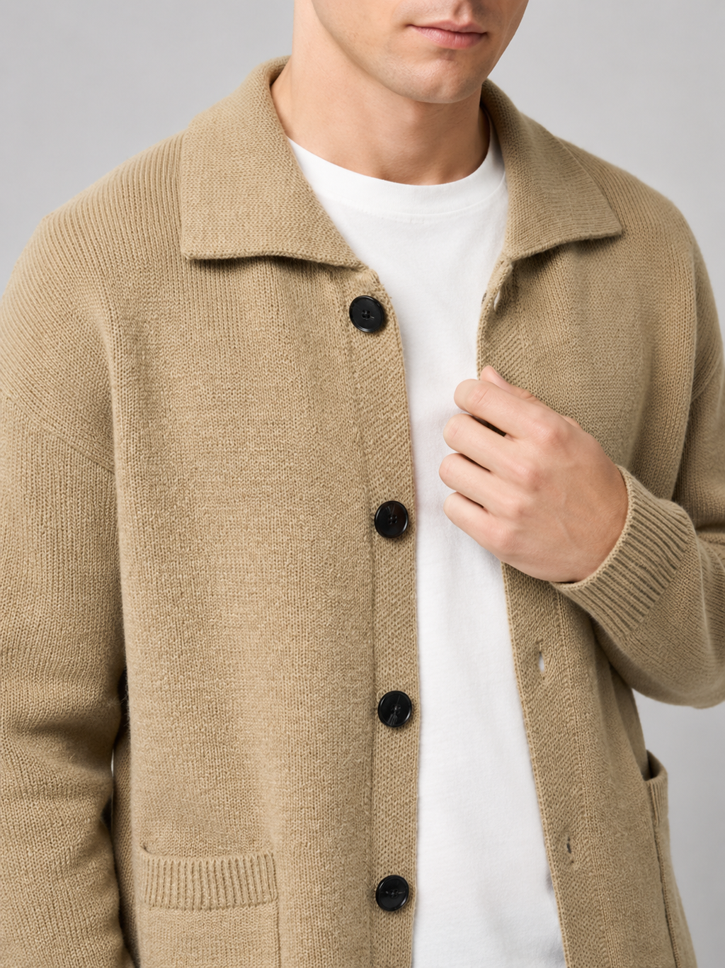 Close up of beige cardigan sweater showing soft knit texture and refined lapel button detail