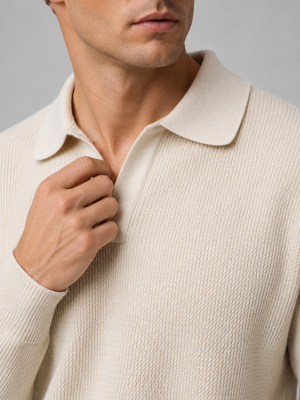 Close up of beige knit polo sweater showing soft textured fabric and refined v neck collar detail