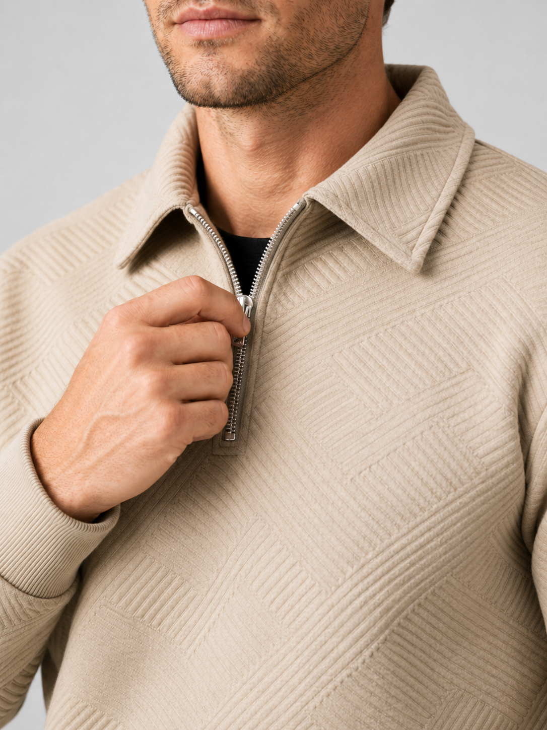 Close up of beige quarter zip sweater showing soft knit texture and refined zipper collar detail