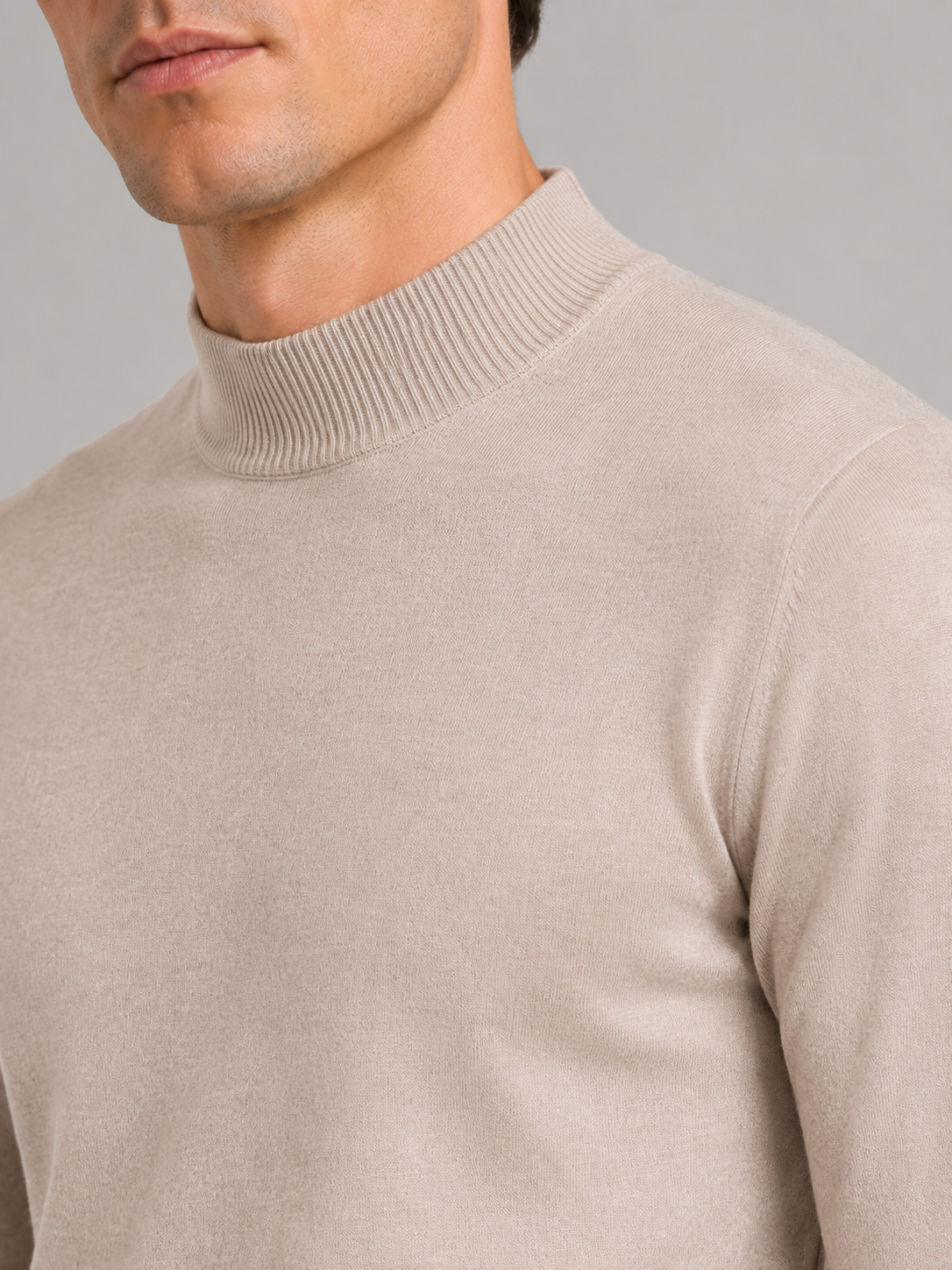 Close up of beige mock neck sweater showing soft knit texture and refined collar detail