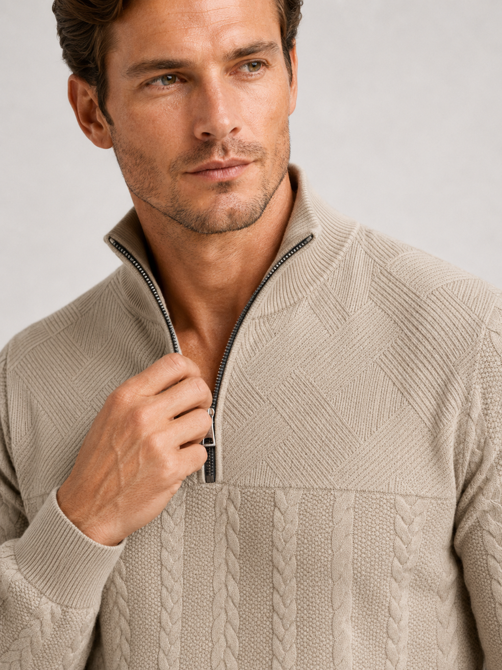 Close up of beige jacquard sweater showing textured knit pattern, quarter zip, and warm fabric detail