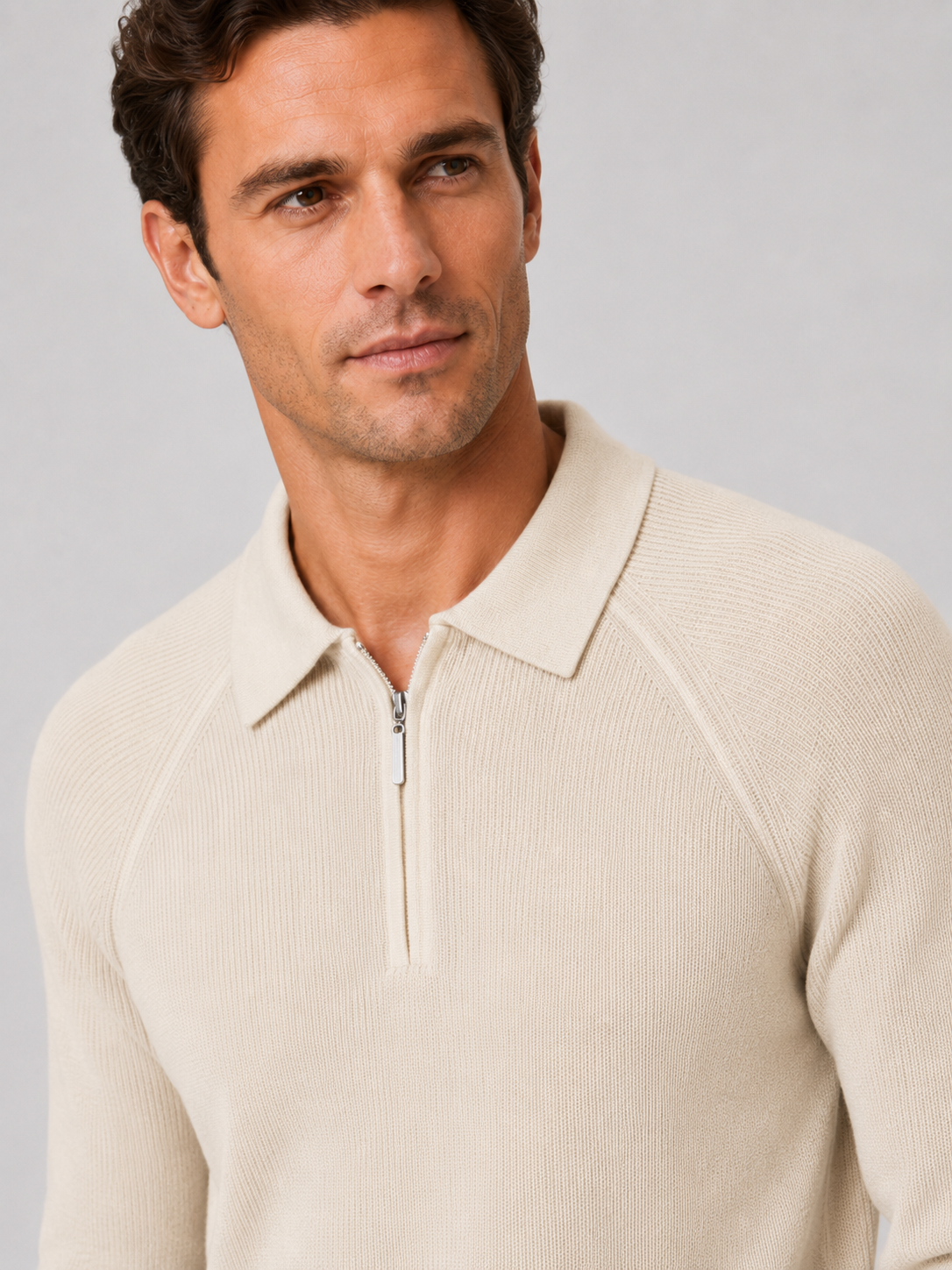 Close-up of a khaki quarter zip polo sweater showing the knit texture, zipper, collar, cuffs, and stitching