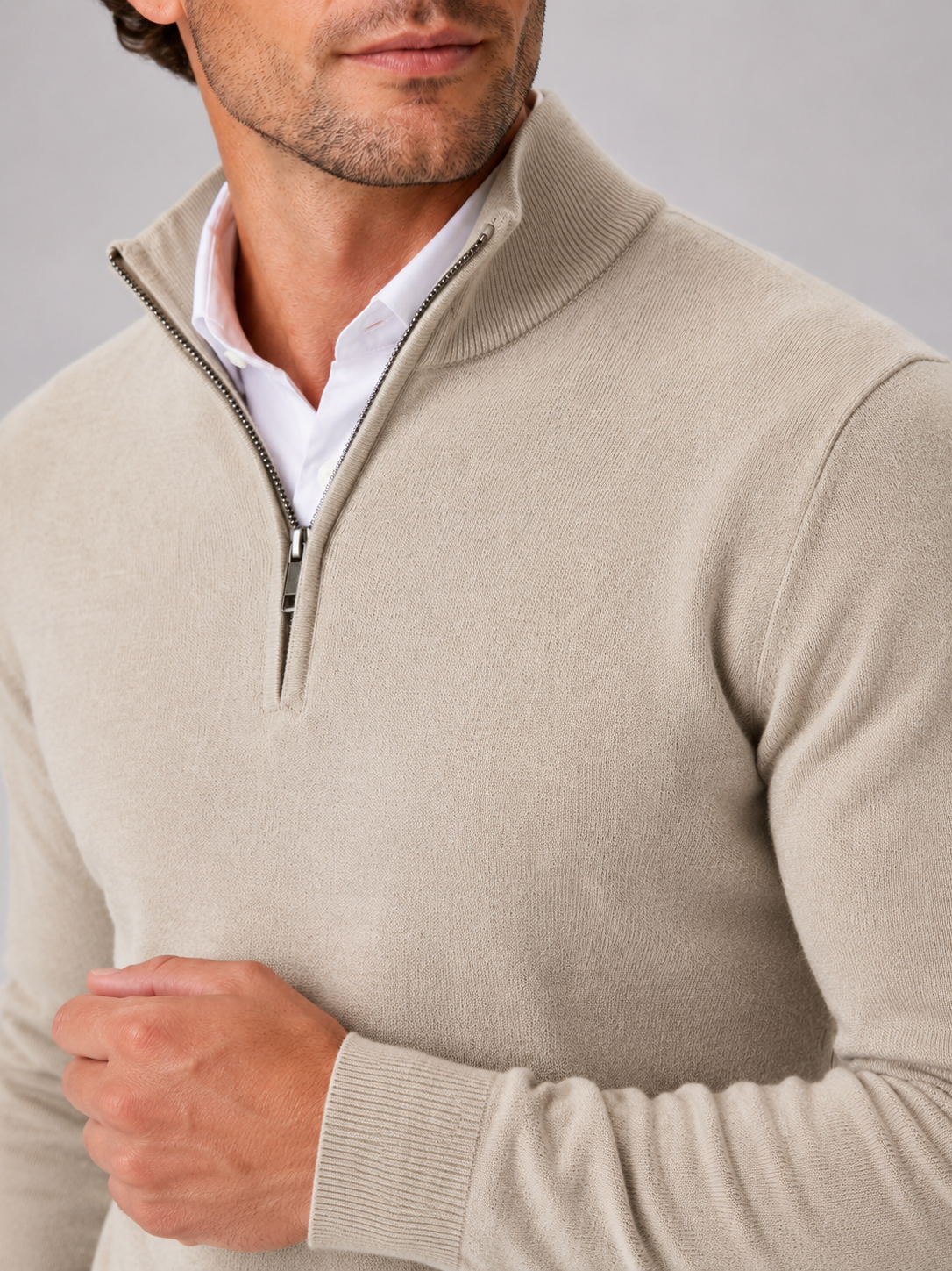 Close up of beige quarter zip sweater showing soft knit texture and mock neck zipper detail