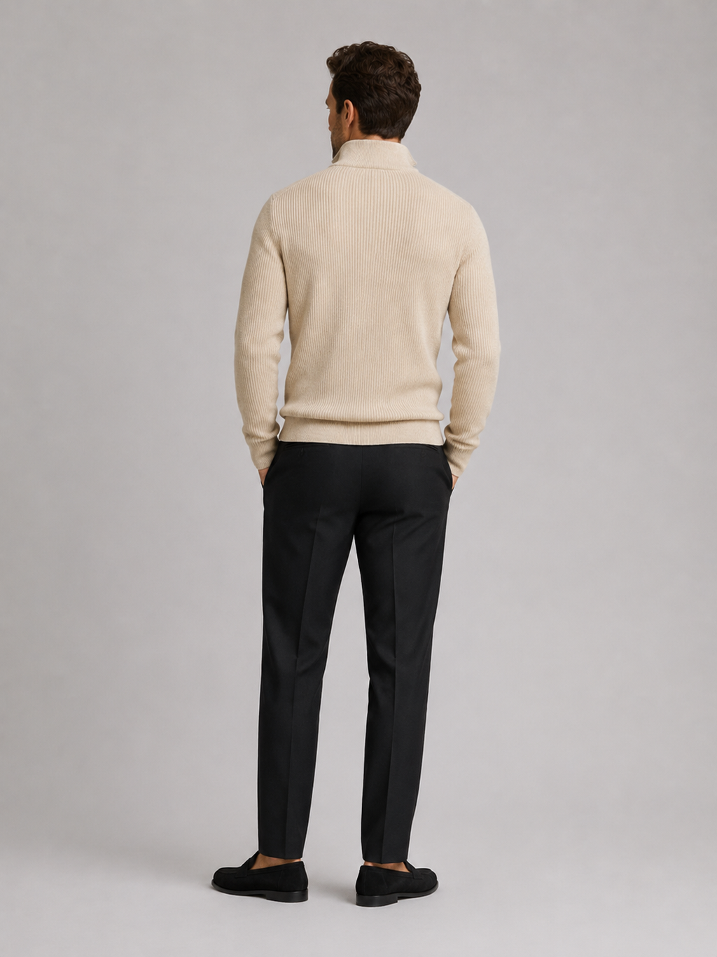 Back view of a man wearing a beige quarter zip sweater showing the slim fit, long sleeves, and clean knit finish