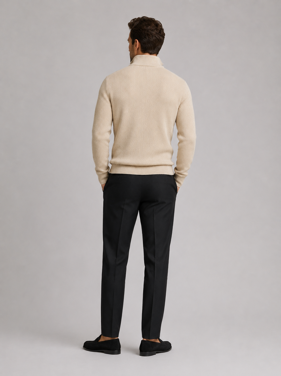 Back view of a man wearing a beige quarter zip sweater showing the slim fit, long sleeves, and clean knit finish