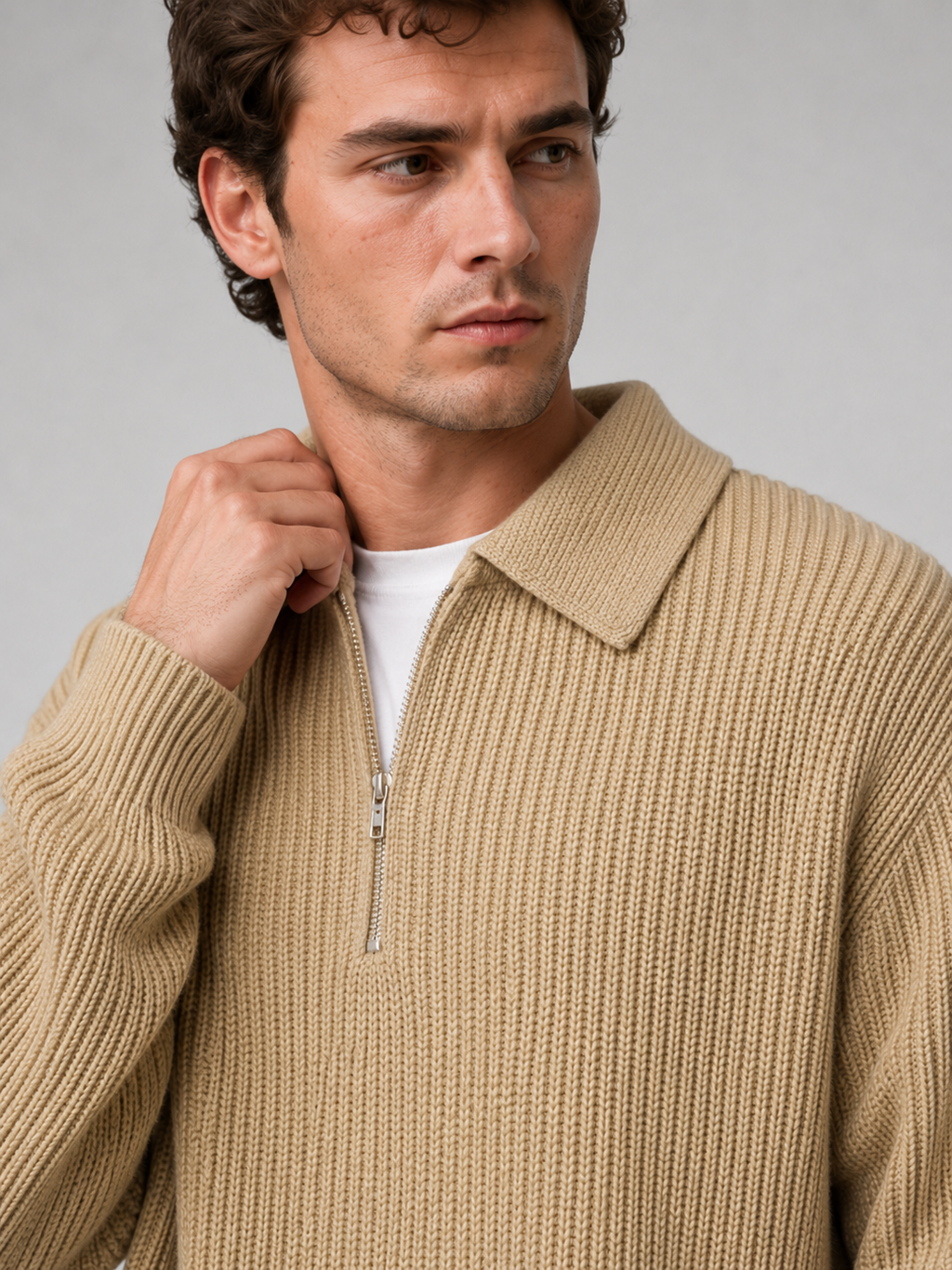 Close up of beige quarter zip polo sweater showing soft knit texture and turn down collar zipper detail