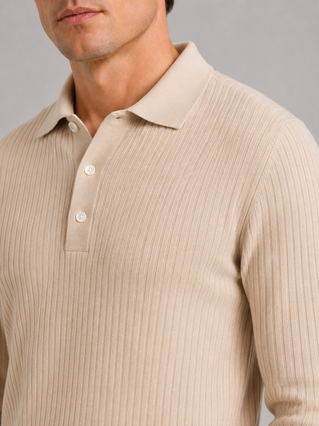 Close up of beige ribbed polo shirt showing soft textured fabric and refined collar detail