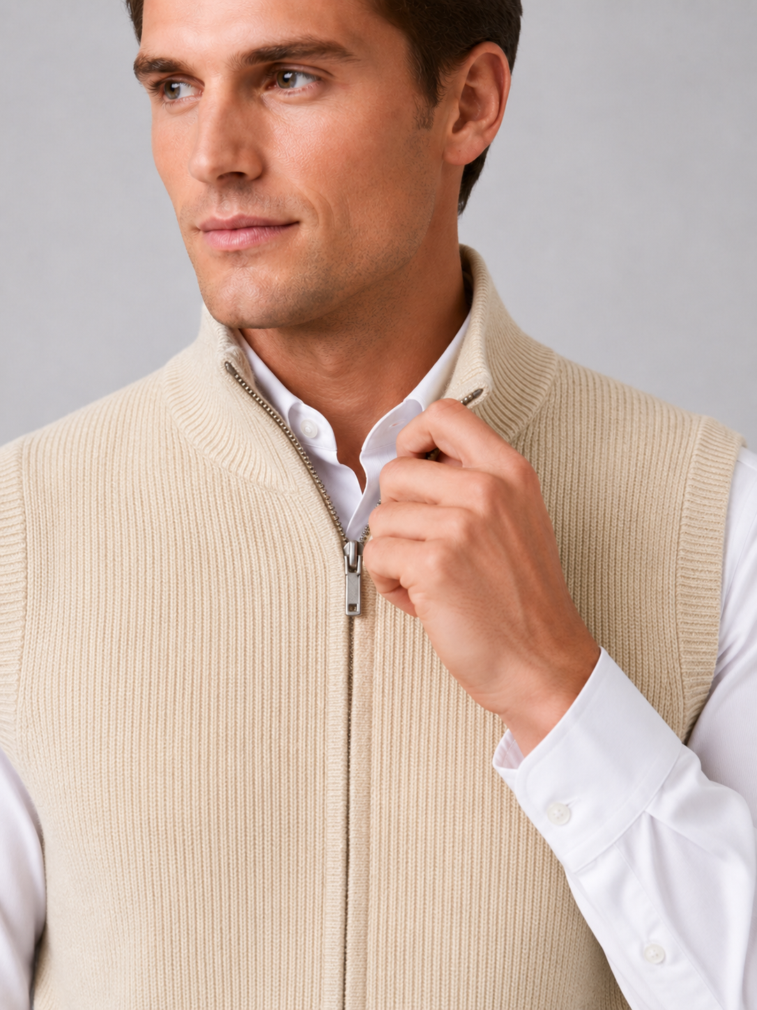 Close up of beige full zip sweater vest showing soft knit texture and mock neck zipper detail