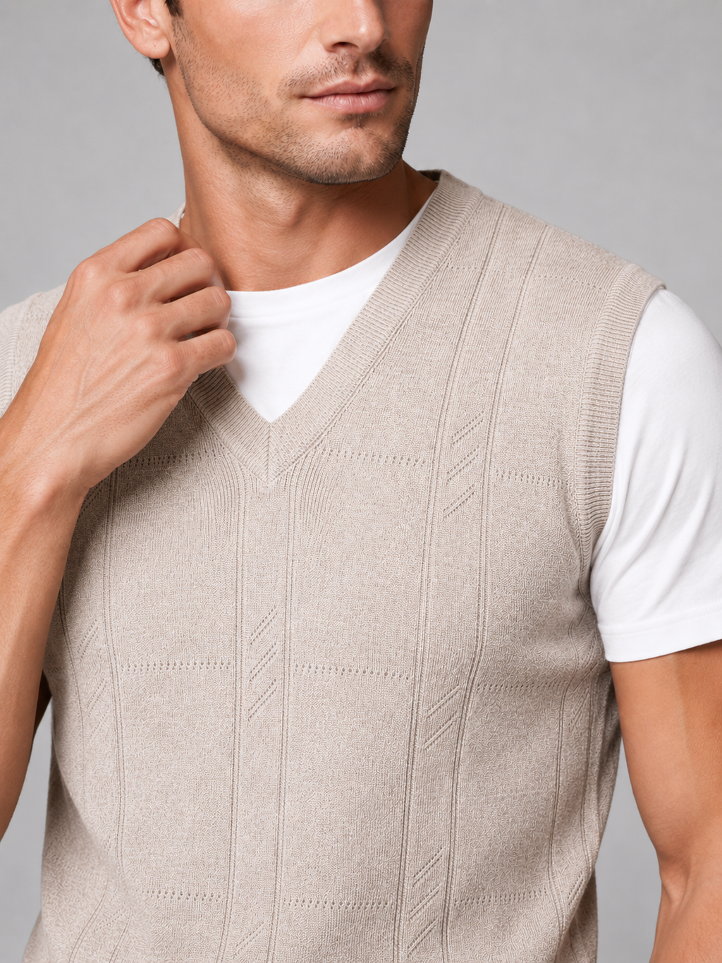 Close up of beige sweater vest showing soft knit texture and classic v neck detail