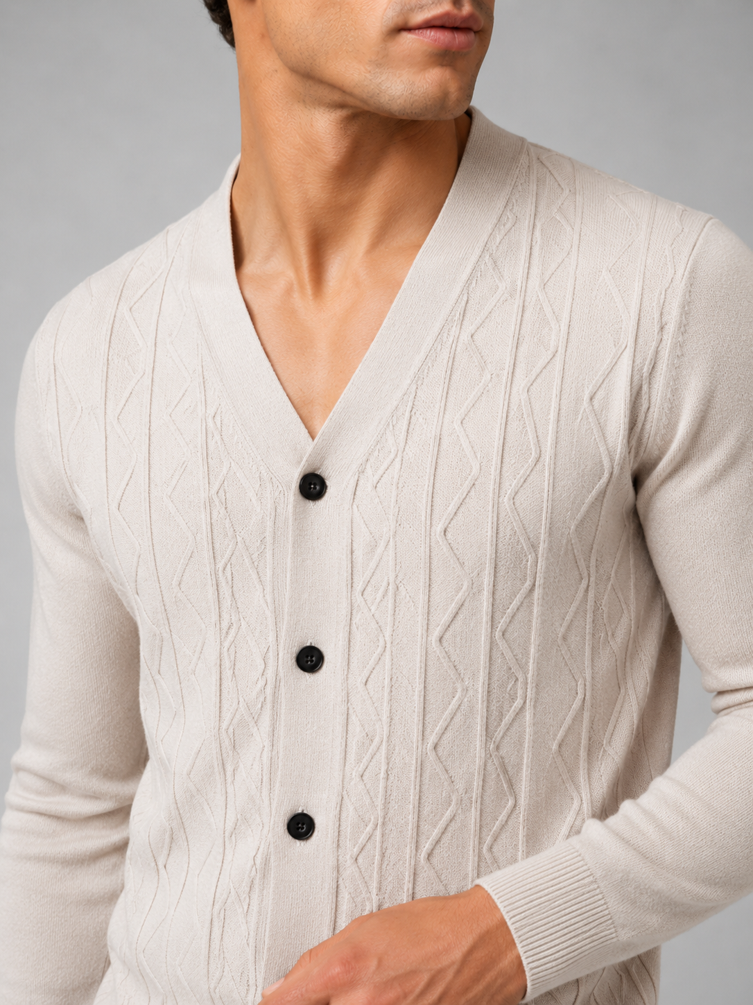 Close up of beige knit cardigan showing soft lightweight texture and refined button front detail