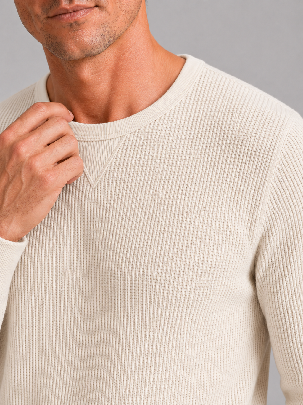 Close up of beige waffle knit shirt showing textured thermal fabric and soft knit detail