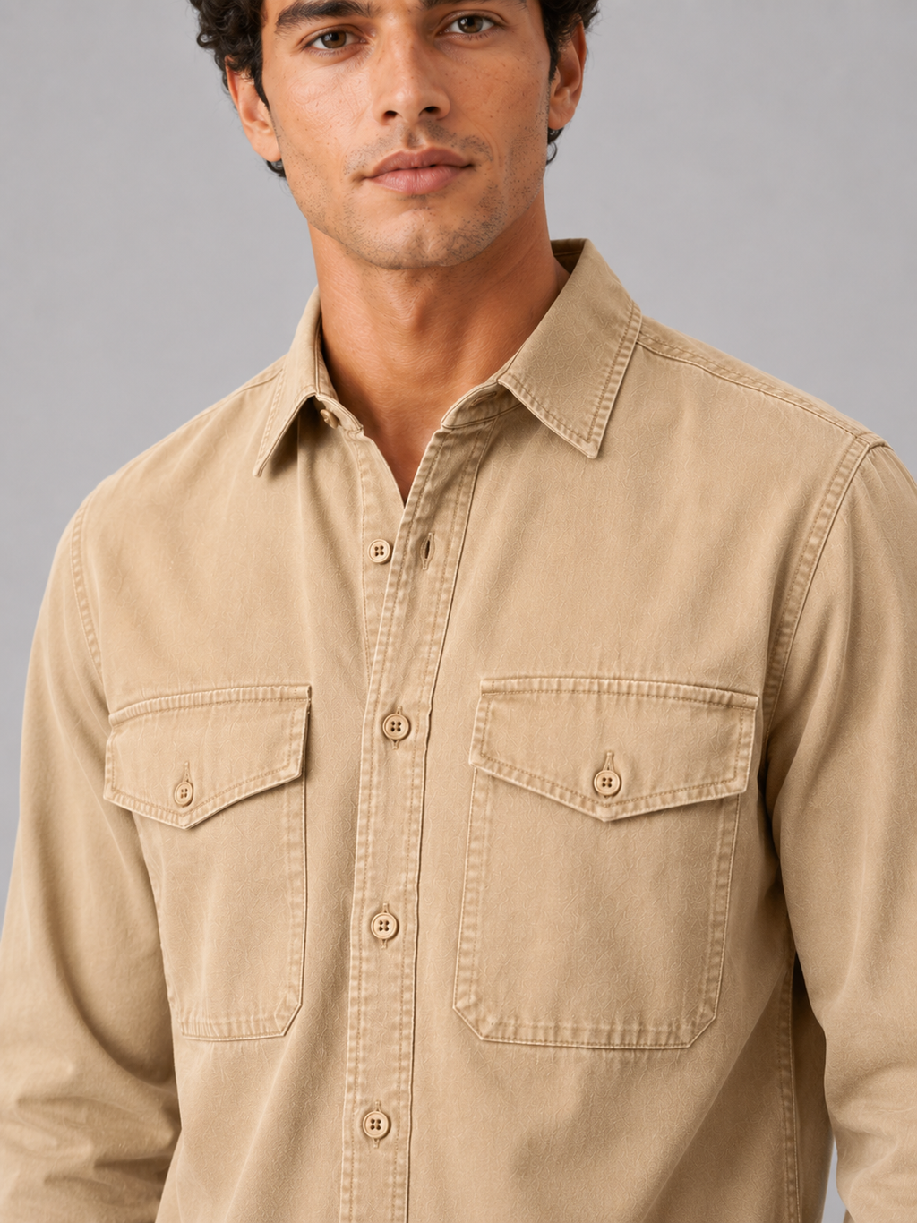 Close up of beige washed cotton work shirt showing soft fabric texture and pocket detail