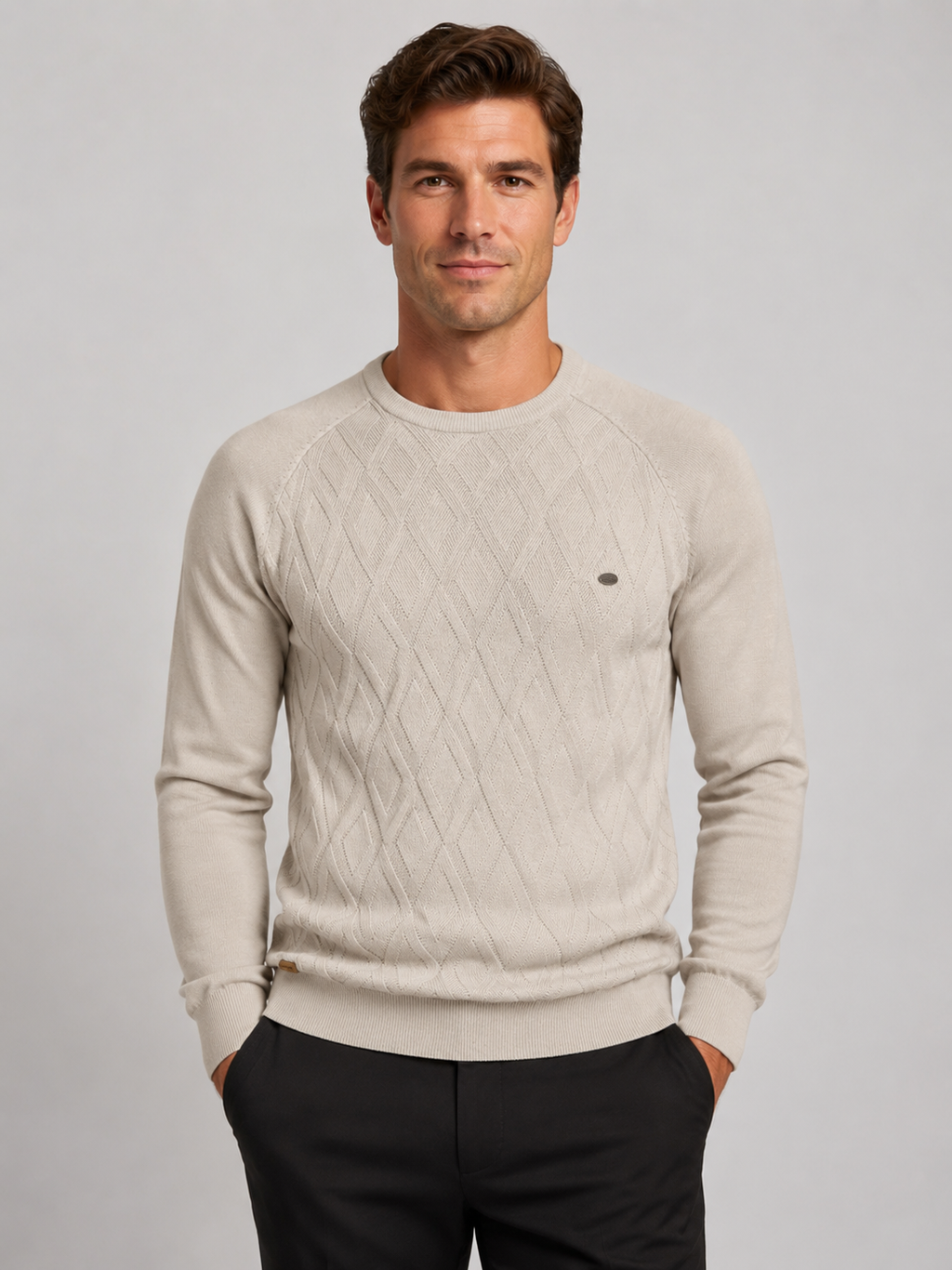 Front view of a man wearing a beige argyle crew neck sweater with long sleeves and a warm knit pattern