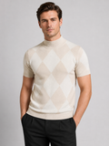 Front view of a man wearing a beige argyle turtleneck T-shirt with a slim fit, diamond lattice pattern, short sleeves, and soft knit construction