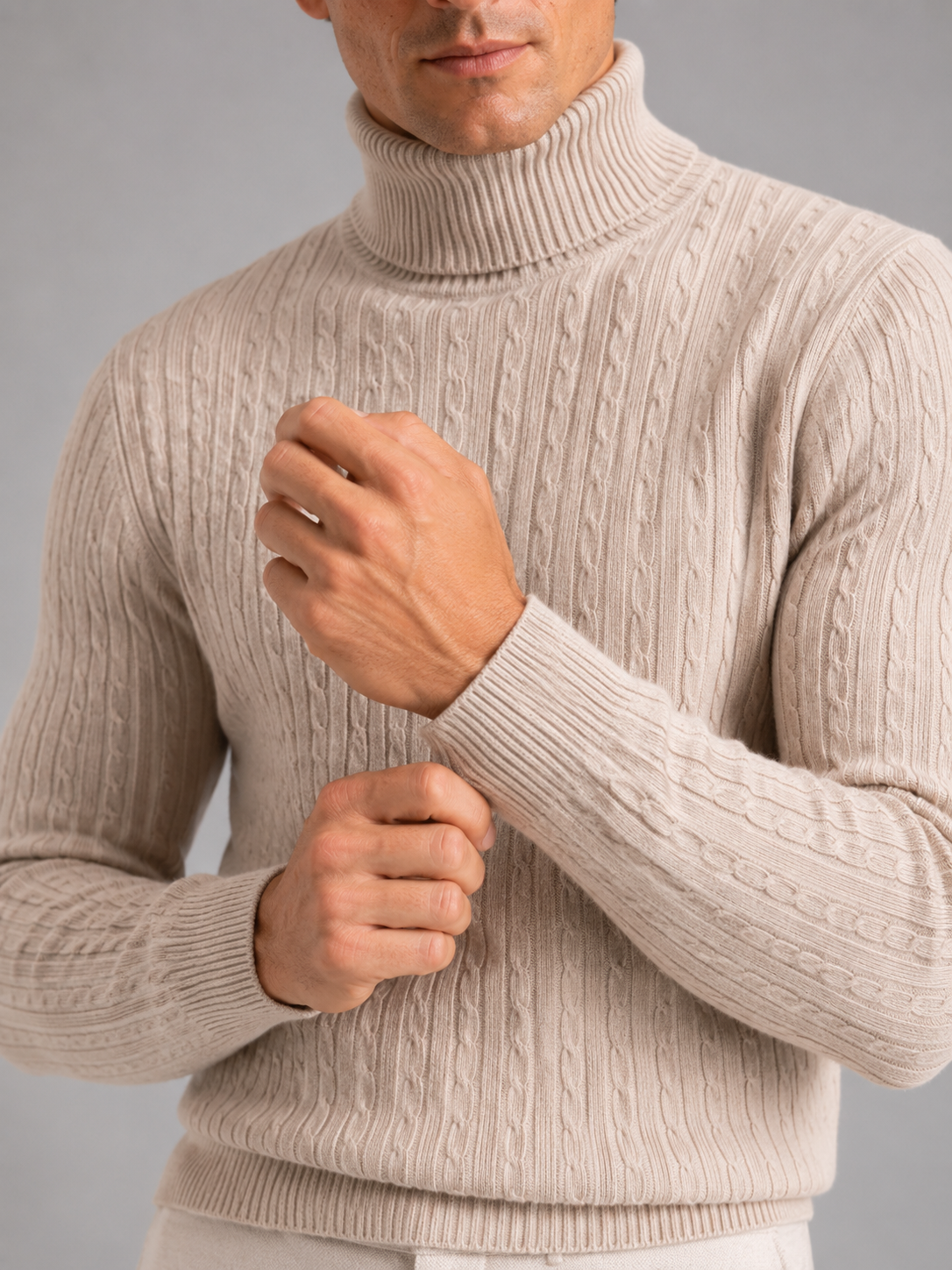 Close up of beige cable knit turtleneck showing thick textured fabric and warm collar detail