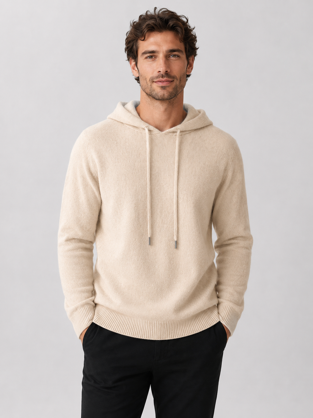 Front view of a man wearing a beige wool hoodie sweater with a soft knit design, attached hood, and long sleeves