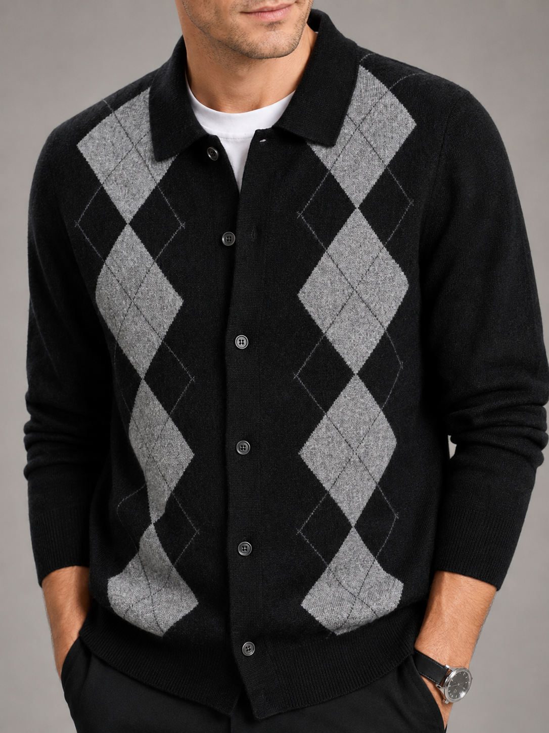 Close-up of a beige argyle cardigan sweater showing the diamond pattern, thick knit texture, buttons, turn-down collar, ribbed cuffs, and hem