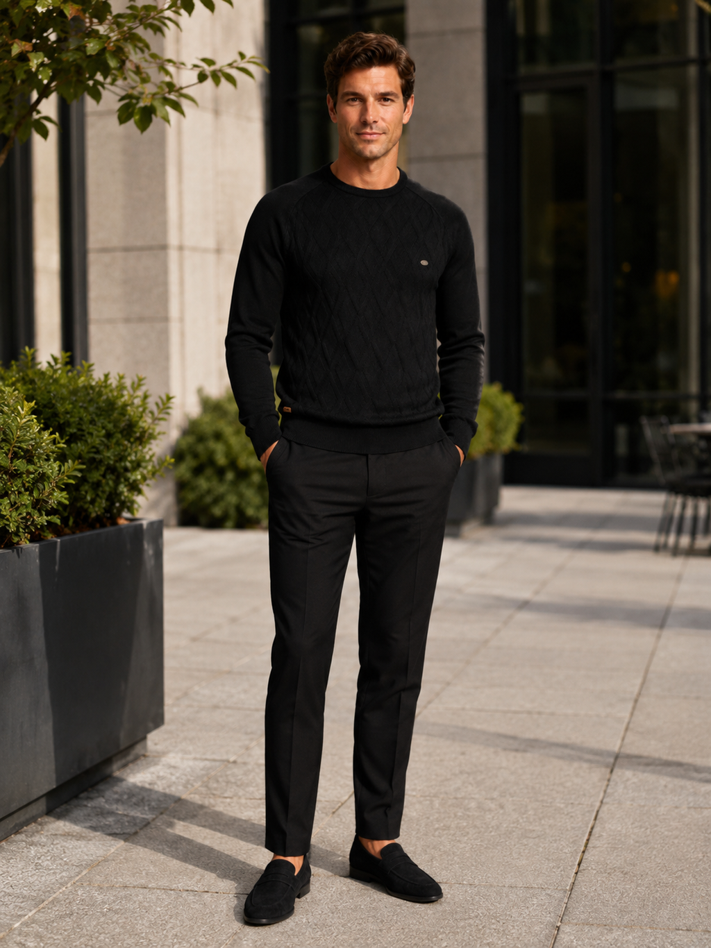 Man wearing a black argyle crew neck sweater in a modern business casual winter outfit