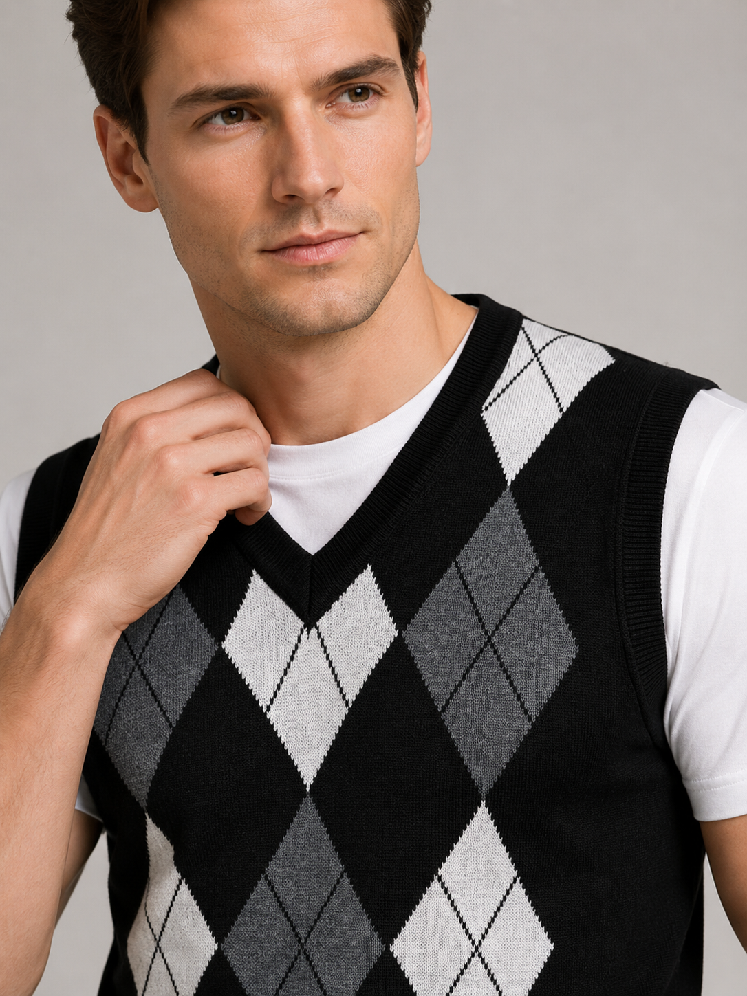 Close up of black argyle sweater vest showing classic diamond knit pattern and refined v neck detail