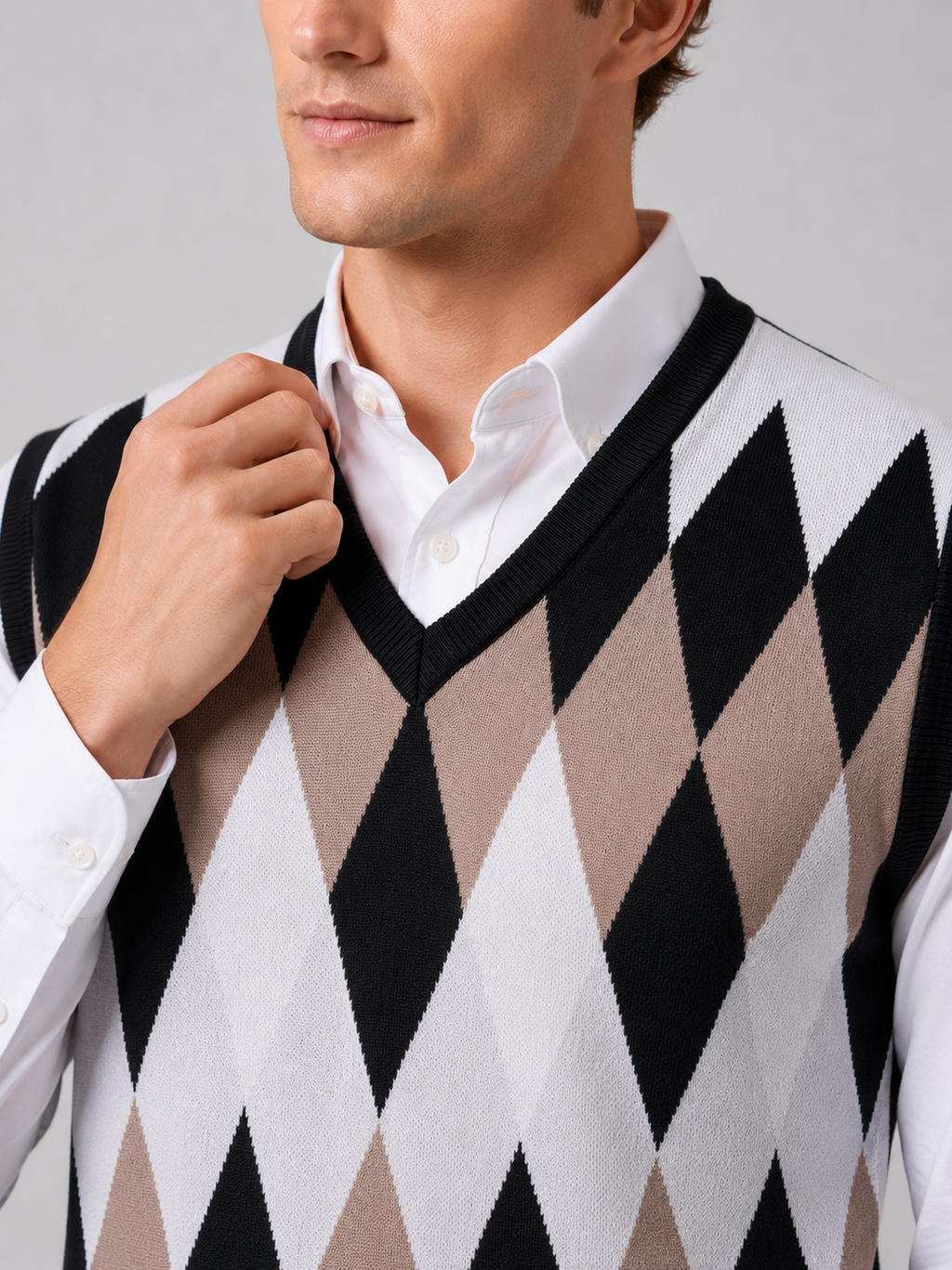 Close up of black argyle sweater vest showing classic diamond knit pattern and refined v neck detail