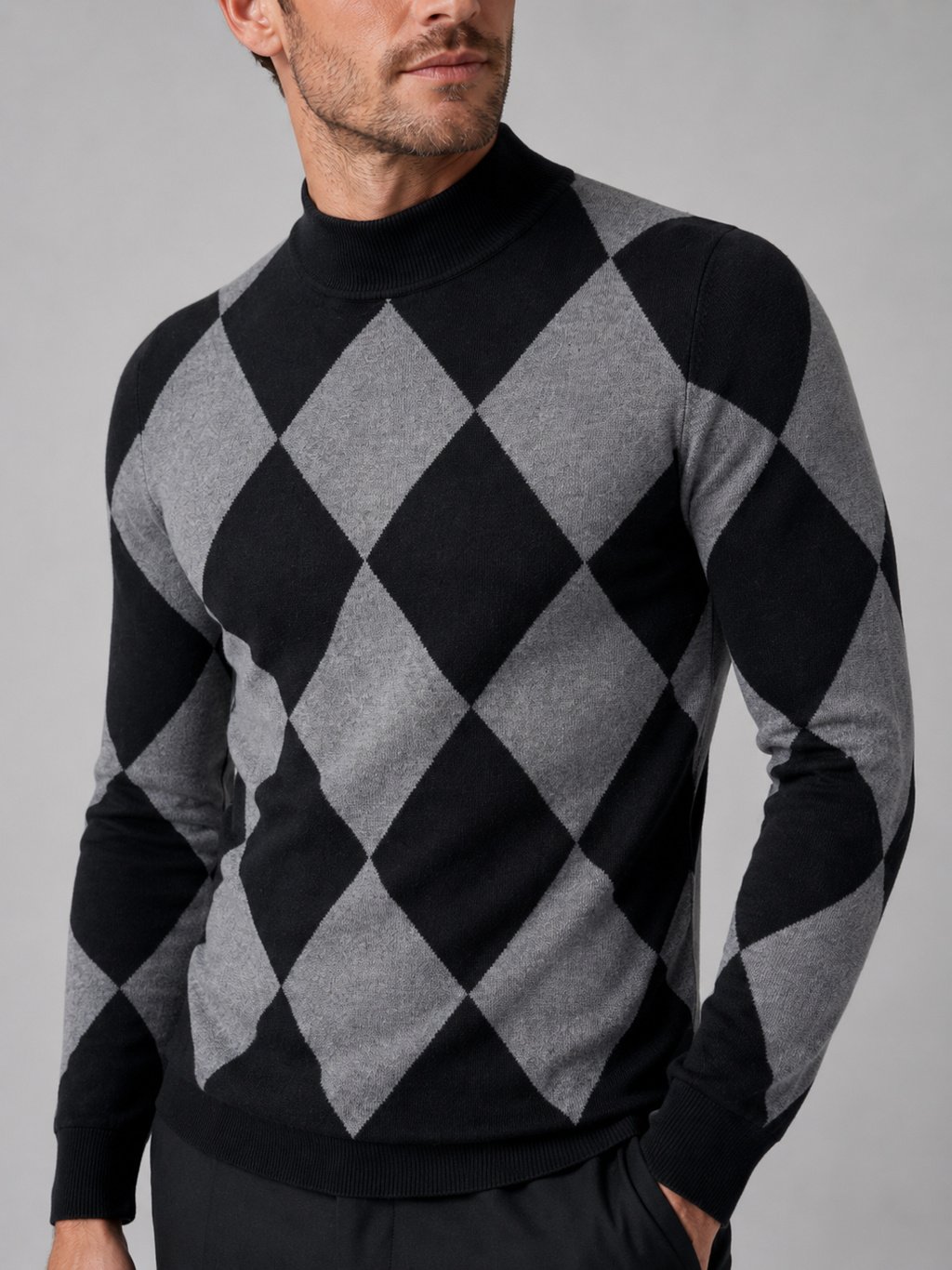 Close-up of a black argyle turtleneck sweater showing the diamond knit pattern, stretch knit texture, turtleneck collar, ribbed cuffs, and hem