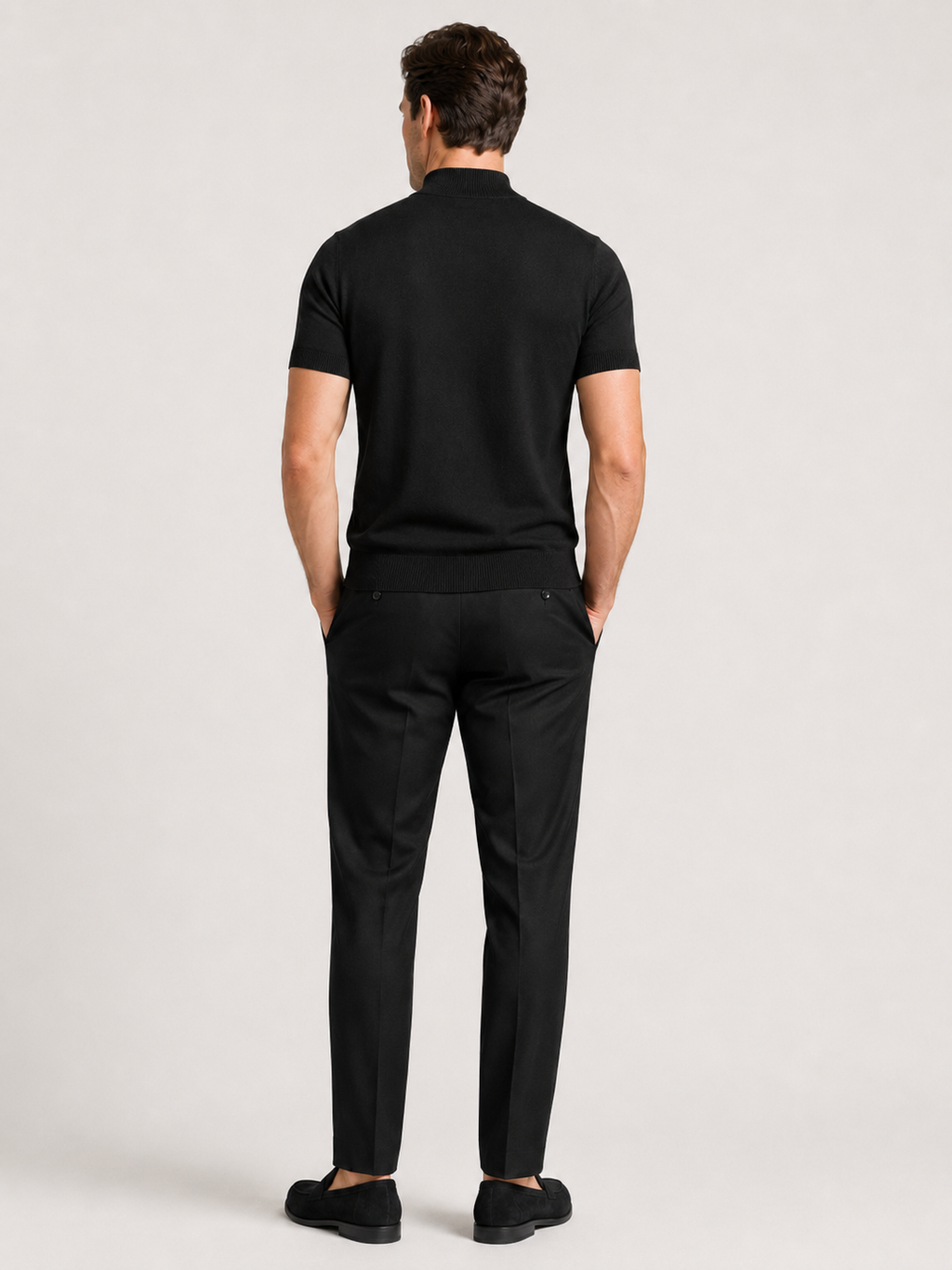 Back view of a man wearing a black argyle turtleneck T-shirt showing the fitted silhouette, short sleeves, and smooth knit fabric