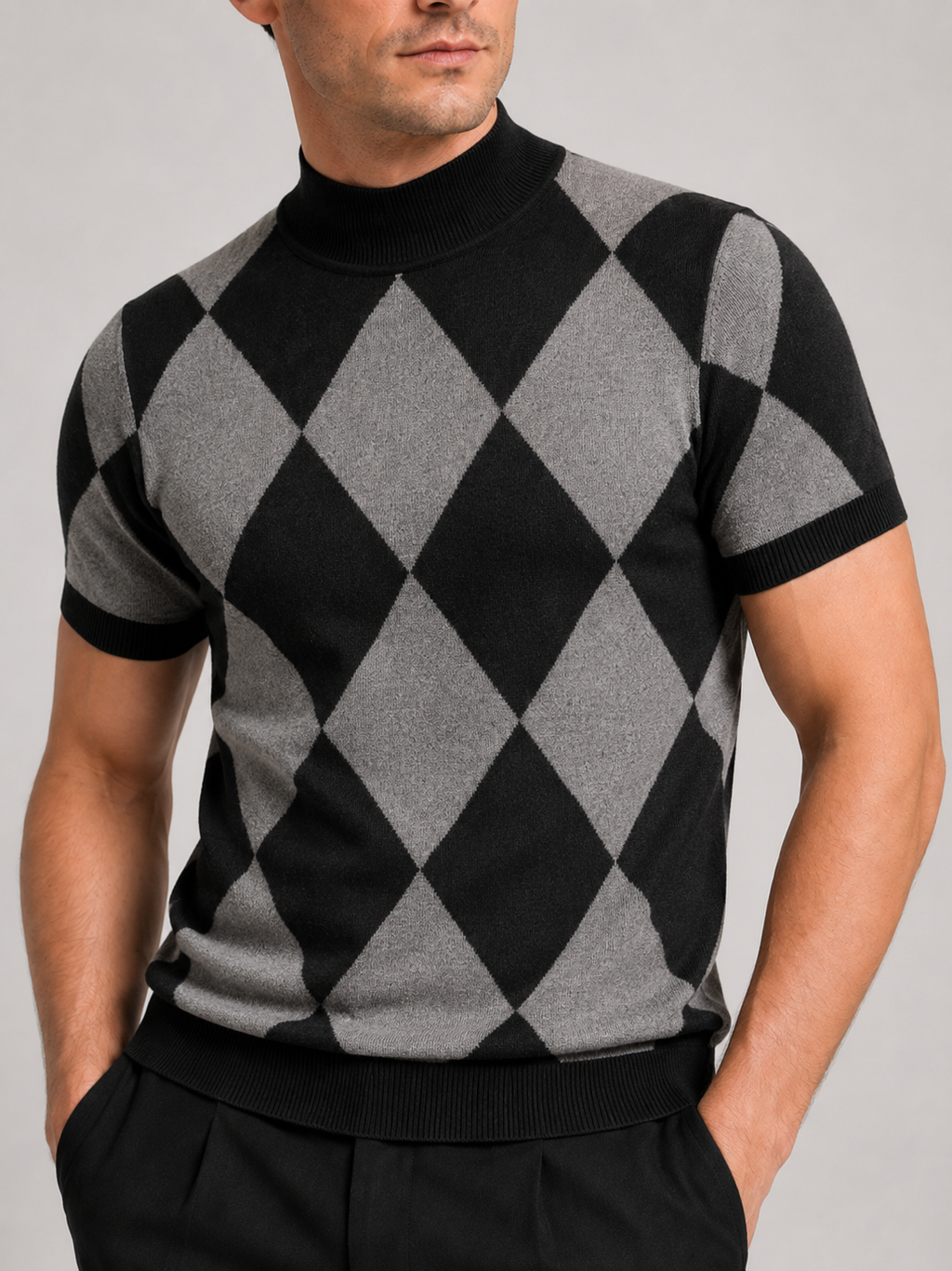 Close-up of a black argyle turtleneck T-shirt showing the diamond lattice pattern, knit texture, high neckline, short sleeve cuffs, and stitching details