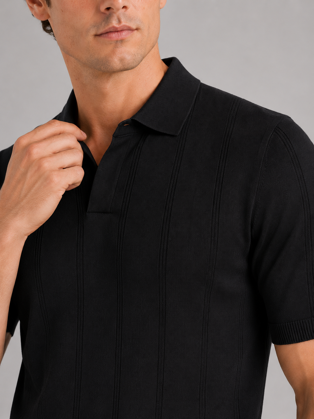 Close up of black knit polo shirt showing soft breathable fabric and refined collar detail