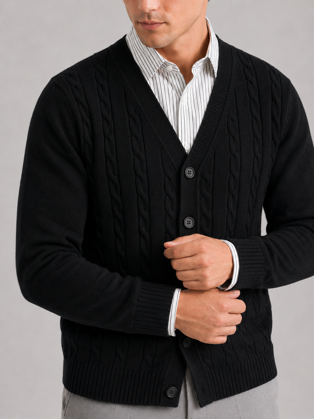 Close up of black cable knit cardigan showing soft textured fabric and button front detail