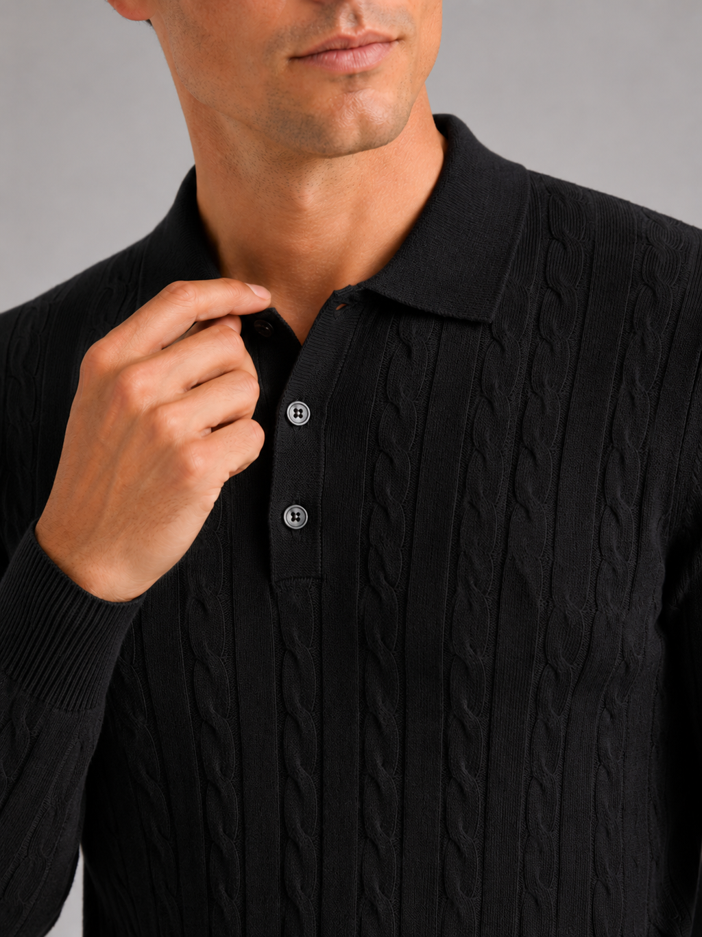 Close up of black cable knit polo showing soft textured fabric and refined collar detail