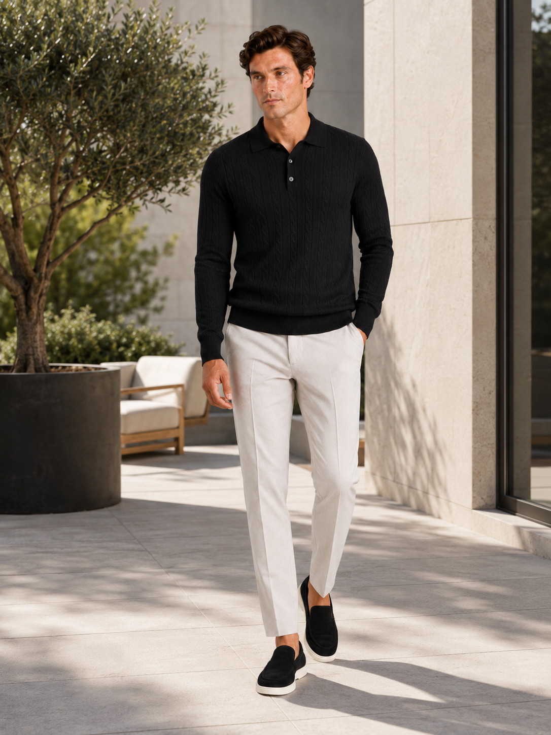 Man styling black cable knit long sleeve polo in a sleek winter lifestyle outfit