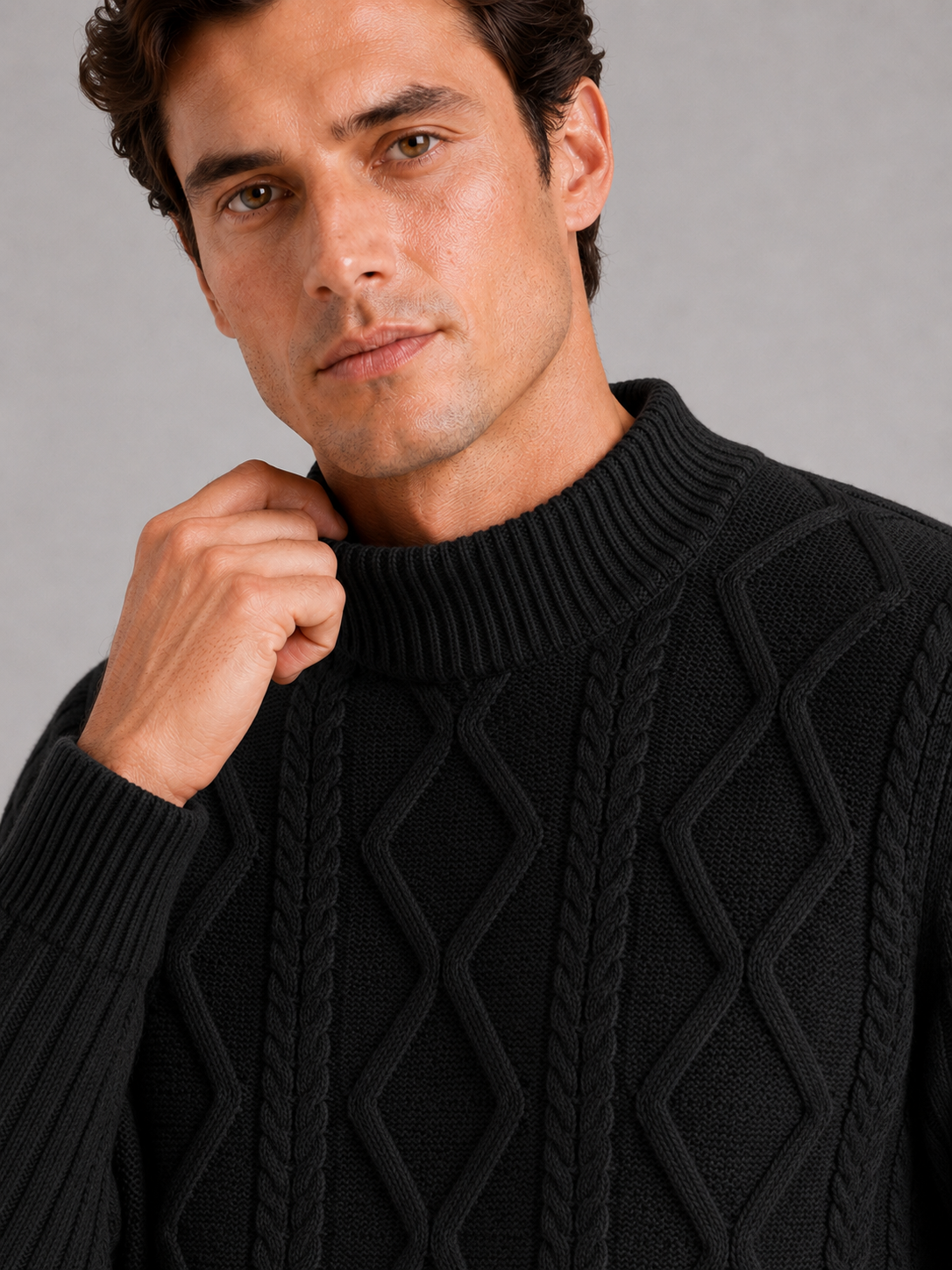 Close up of black mock neck sweater showing jacquard twist cable knit texture and soft warm fabric