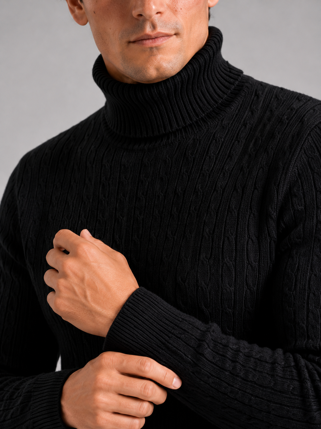 Close up of black cable knit turtleneck showing thick textured fabric and warm collar detail